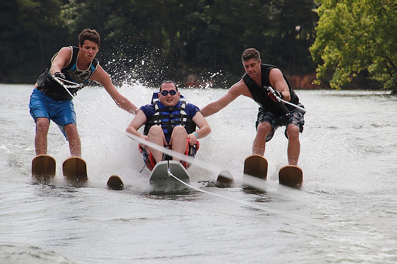 Side skiers accompany one of the disabled participants Saturday in the annual SPARC watersports day at Possum Creek. / SPARC photo/Keith Arimura
