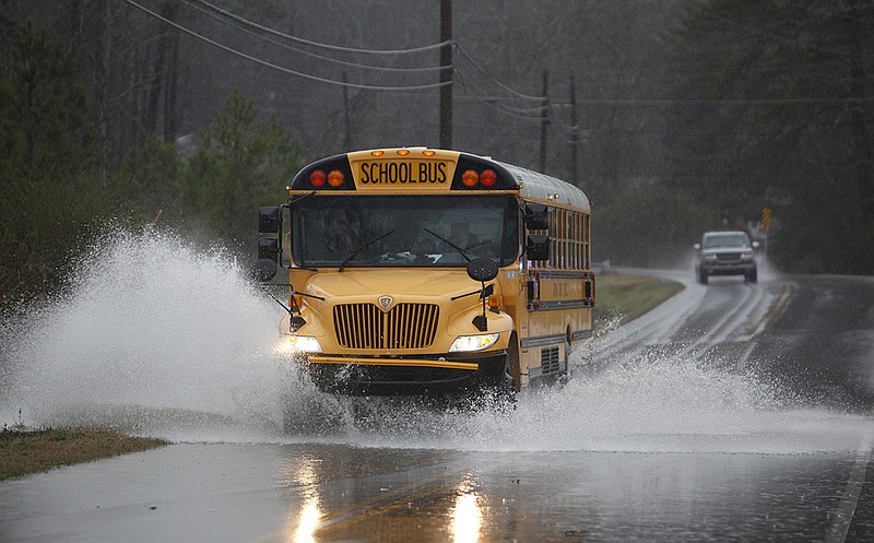A school bus splashes through high water as a creek runs over Poplar Springs Road in Ringgold, Ga. The road will be resurfaced thanks to a Transportation Improvement Program grant from the Georgia Department of Transportation.