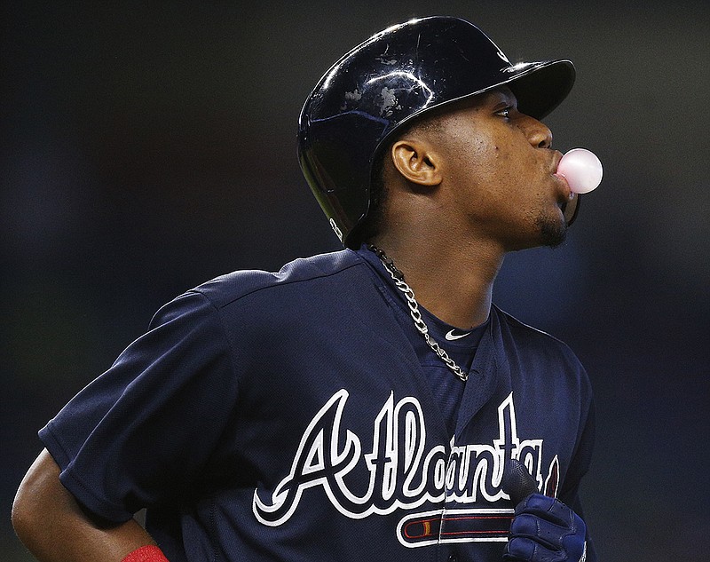 Atlanta Braves baserunner Ronald Acuna Jr. blows a chewing gum bubble as he heads to first base after a walk during the fifth inning of a baseball game against the Miami Marlins, Tuesday, July 24, 2018, in Miami. The Marlins beat the Braves 9-3. (AP Photo/Brynn Anderson)

