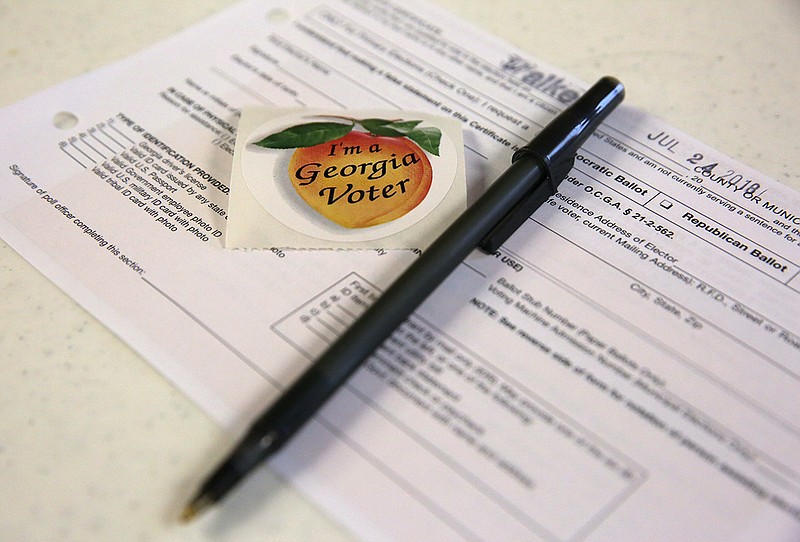 Paperwork and voting stickers sit out for voters of the Georgia primary election Tuesday, July 24, 2018 at the Chattanooga Valley Church of the Nazarene in Flintstone, Georgia. 