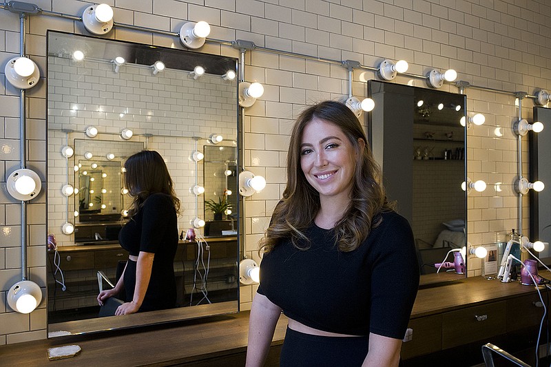 Hair salon owner Erika Wasser stands in her Glam+Go studio, Thursday, July 19, 2018, in New York.  She owns nine salons in three cities. (AP Photo/Mark Lennihan)
