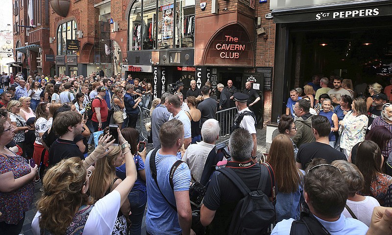 People queue outside the Cavern Club in Liverpool, England, before an exclusive gig by former Beatles member Paul McCartney, Thursday July 26, 2018. The former Beatle will take to the stage at the famous venue on Mathew Street for a one-off exclusive gig. (Peter Byrne/PA via AP)