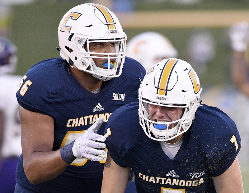 UTC left tackle Malcolm White, left, helps quarterback Nick Tiano up during a home game against Western Carolina last September. White is one of four returning starters on the offensive line.