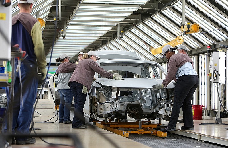 Volkswagen employees work around a car on the assembly line at the plant in Chattanooga. The automaker employs about 3,500 people at the factory.