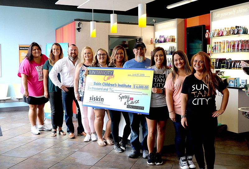 At the Sun Tan City check presentation are, from left, Candice Phillips, Molly Reidy, Garrett Bruner, Angela Harmon, Kristen House, Katie Cason, Tom Harmon, Catherine Frazier, Coley Norwood and Brianna Collum. (Contributed Photo from Siskin Children's Institute)