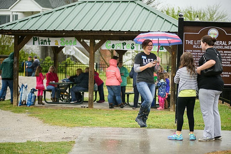 Chrissie Brown greets attendees during LIFT's rainy Earth Day event, which drew 150 people despite the inclement weather. (Contributed photo by Tina Pinkston)