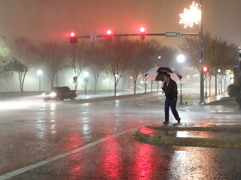 A lone person crosses Broad Street at 4th during a heavy downpour at 9:45 p.m. on November 28, 2016. / Staff photo by Tim Barber
