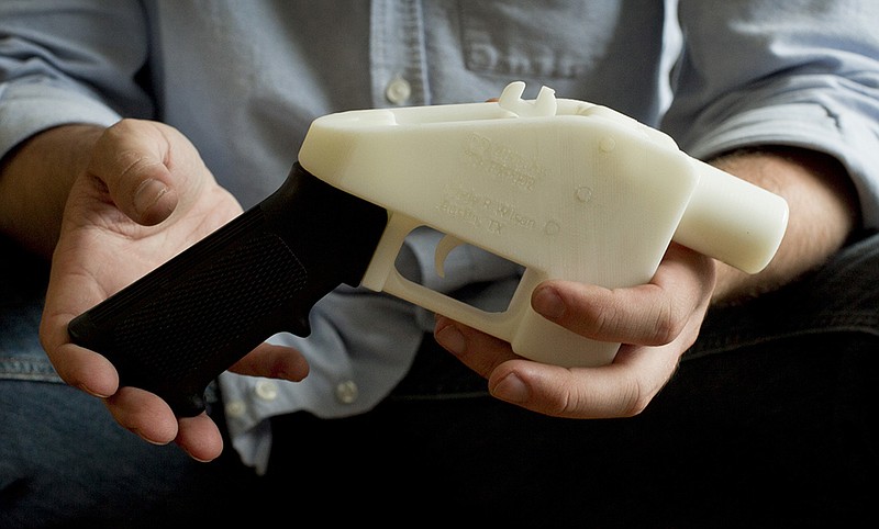 FILE - In this May 10, 2013, file photo, Cody Wilson holds what he calls a Liberator pistol that was completely made on a 3-D-printer at his home in Austin, Texas. 