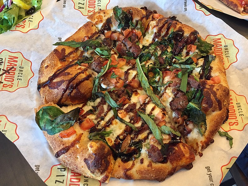 The Steak & Blue pizza has garlic olive oil, grilled steak, mozzarella, blue cheese, tomatoes, spinach, basil and a drizzle of balsamic glaze.