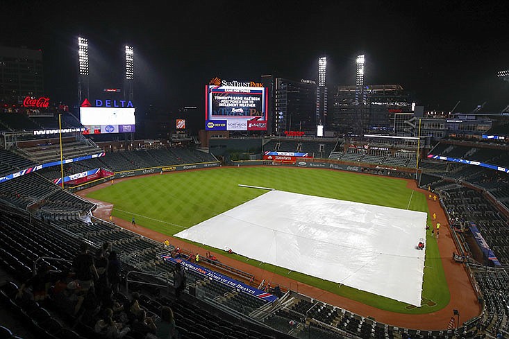 The scoreboard at SunTrust Park shows an announcement that Wednesday night's baseball game between the Miami Marlins and the Atlanta Braves was postponed due to rain.

