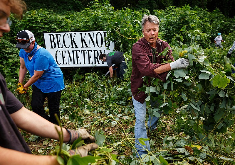 Alan Brown, right, and Andrea Becksvoort clearn brush during a cleanup of the North Shore's historic Beck Knob Cemetery on Saturday, July 28, 2018, in Chattanooga, Tenn. Volunteers worked through the morning to clear growth from the century-old cemetery for African Americans, which was established by landowner Joshua Beck in the late 1800s and was active into the 1940s. The cemetery was rediscovered in 2015 by contractors constructing homes on Dartmouth Street for developer Green Tech Homes.