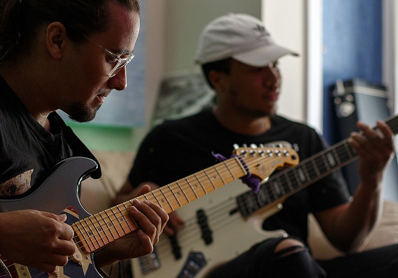 Tyler Martelli, left, and Jared White play guitar and bass while jamming in the studio at The Flock.