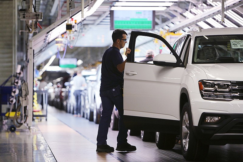 A Volkswagen employee walks around an Atlas SUV as he checks on its doors at the Chattanooga assembly plant.