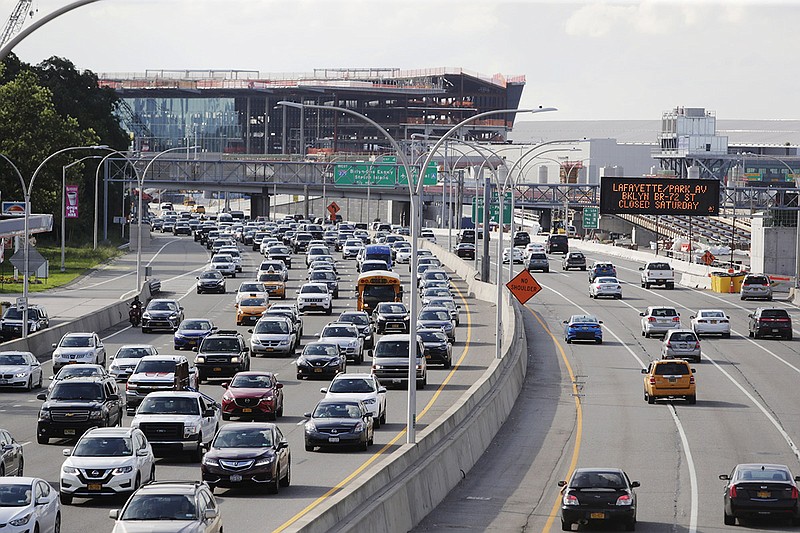 In this Aug. 1, 2018, photo, cars on the Grand Central Parkway pass LaGuardia Airport in New York. The Trump administration has proposed rolling back tougher Obama-era gas mileage requirements that are set to take effect after 2020. (AP Photo/Frank Franklin II)