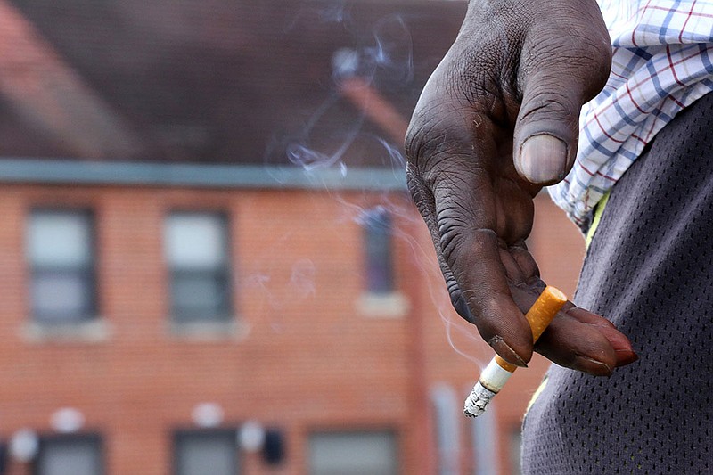Staff photo by Erin O. Smith / 
A East Lake Courts resident, who didn't want to be named, smokes along the road beside his apartment at East Lake Courts Friday, August 3, 2018 in Chattanooga, Tennessee. A new rule that bans smoking in public housing developments went into effect in Chattanooga on July 31.