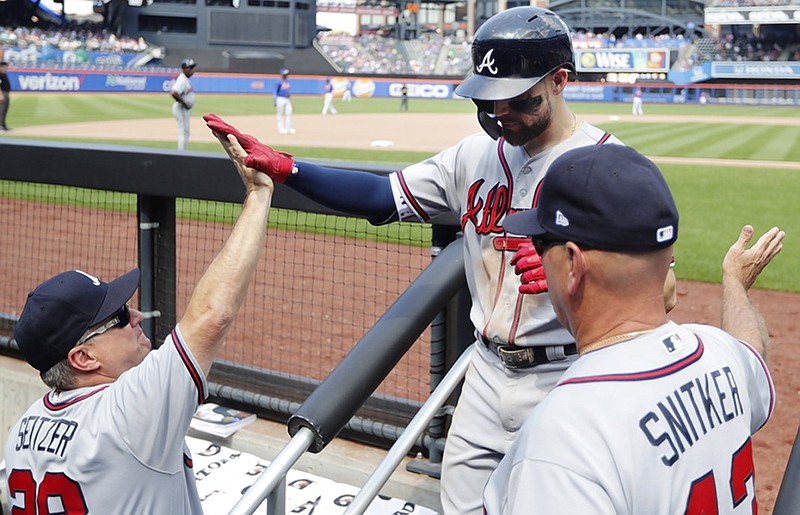 The Atlanta Braves' Ender Inciarte, center, is congratulated by manager Brian Snitker and hitting coach Kevin Seitzer after slugging a two-run home run during the seventh inning of Sunday's 5-4 win against the Mets in New York.