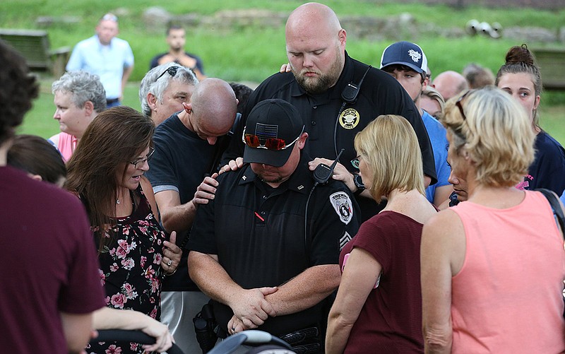 Staff photo by Erin O. Smith / 
Individuals pray over Sgt. Chip Burrow with the Dade County Sheriff's Office during a prayer vigil for Dade County Sheriff's Office Major Tommy Bradford Tuesday, August 7, 2018 in Trenton, Georgia. Burrow was one of the officers involved in the incident that left Bradford injured and in critical condition Tuesday.