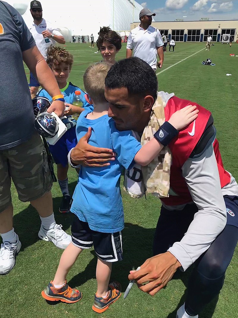 Titans quarterback Marcus Mariota shares a hug with Soddy-Daisy's Nolan Hendricks after Tuesday morning's practice. / Contributed photo by Alan Pressley
