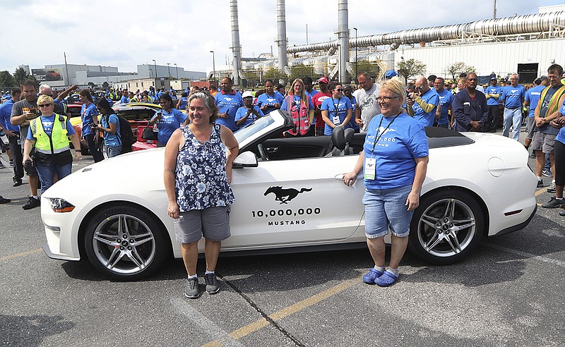 Employees Rose Boylan, left, and Michelle Cotter stand next to the 2019 GT Mustang, the 10 millionth Mustang built by Ford outside the Flat Rock Assembly plant, Wednesday, Aug. 8, 2018 in Flat Rock, Mich. (AP Photo/Carlos Osorio)
