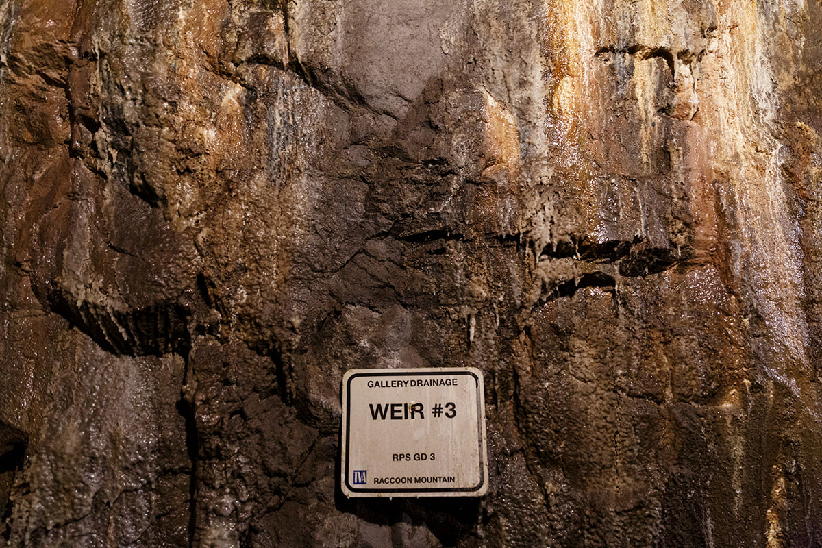 A sign hangs on the rock wall of an access tunnel inside TVA's Raccoon Mountain Pumped-Storage Plant on Friday, Aug. 10, 2018, in Chattanooga, Tenn. The hydroelectric facility halted tours for the public after the September 11 terrorist attacks in 2001, but they began offering tours again this year.