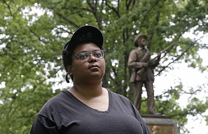 Activist Maya Little stands near the "Silent Sam" Confederate statue on campus at the University of North Carolina in Chapel Hill, N.C., on Tuesday, May 15, 2018.