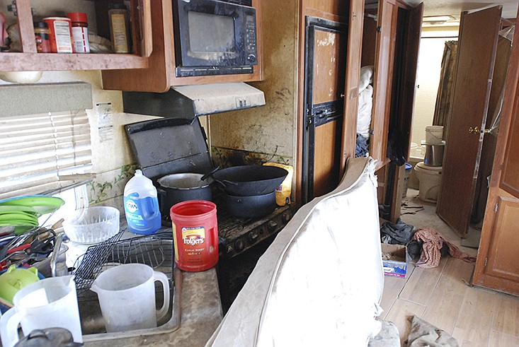 Various items litter the kitchen of a makeshift living compound in Amalia, N.M., on Friday, Aug. 10, 2018, where five adults were arrested on child abuse charges and remains of a boy were found.