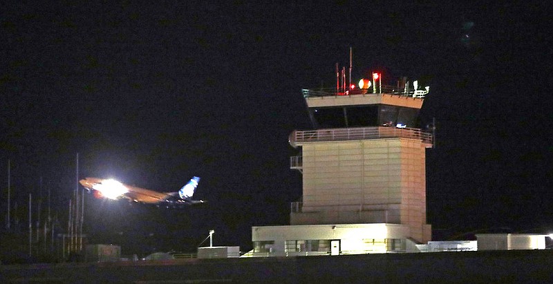 A plane flies past a control tower at Sea-Tac International Airport Friday evening, Aug. 10, 2018, in SeaTac, Wash. An airline mechanic stole an Alaska Airlines plane without any passengers and took off from Sea-Tac International Airport in Washington state on Friday night before crashing near Ketron Island, officials said.