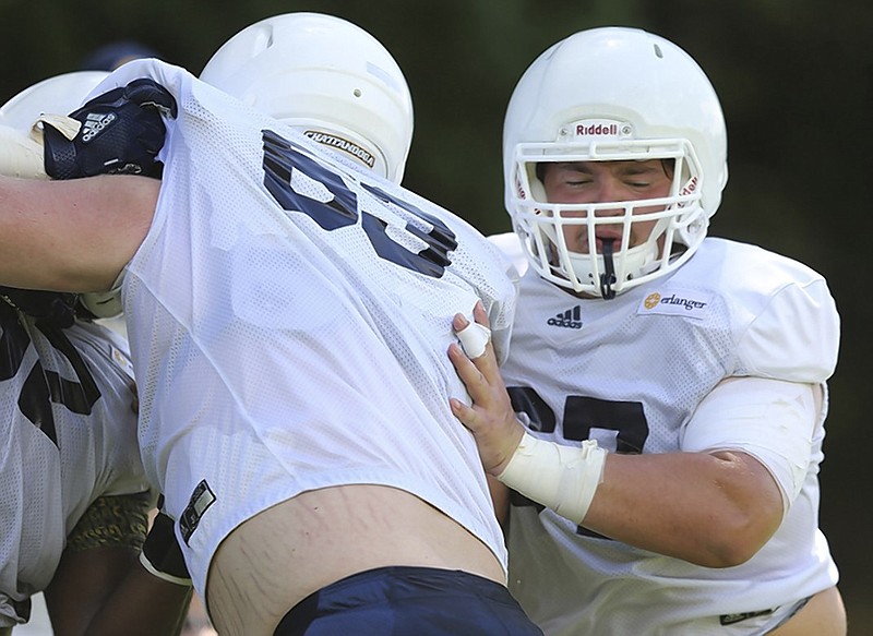 UTC offensive lineman Noah Ramsey, right, goes through drills this past Monday at Scrappy Moore Field.