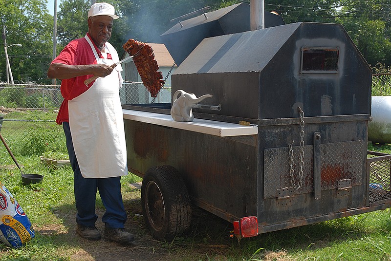 Staff photo by Rachel Turner /
James Hands barbecues on "The Monster," his barbecue pit, in his front yard on Tuesday.  Mr. Hands will be  barbecuing for a Sale Creek Lions Club benefit on Friday and Saturday.