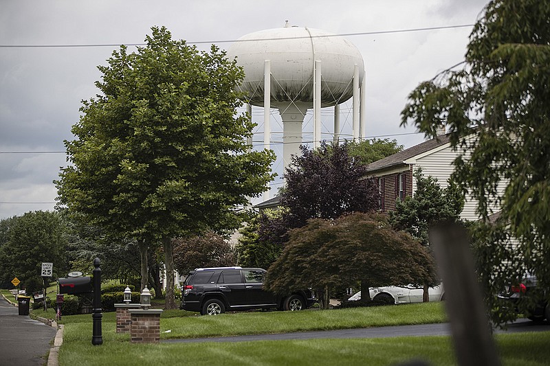 In this Aug. 1, 2018, photo, a water tower stands above a residential neighborhood in Horsham, Pa. In Horsham and surrounding towns in eastern Pennsylvania, and at other sites around the United States, the foams once used routinely in firefighting training at military bases contained per-and polyfluoroalkyl substances, or PFAS. EPA testing between 2013 and 2015 found significant amounts of PFAS in public water supplies in 33 U.S. states. (AP Photo/Matt Rourke)