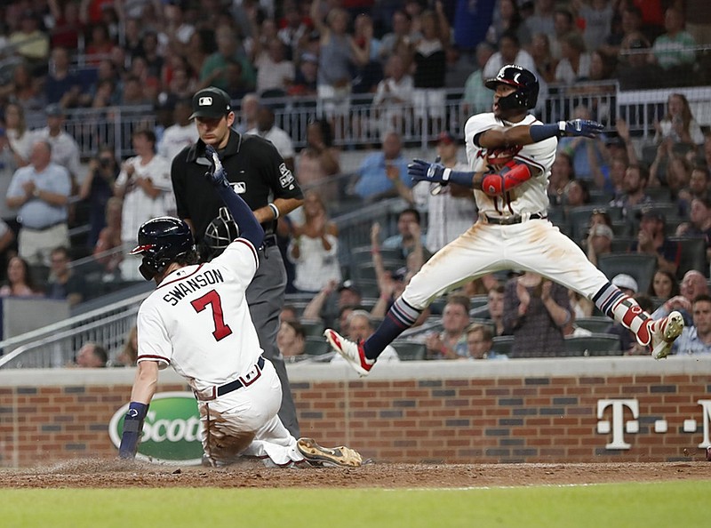 The Atlanta Braves' Ronald Acuna Jr. leaps in reaction as teammate Dansby Swanson scores on Julio Teheran's single in the fifth inning Thursday night in Atlanta. The Rockies won 5-3.