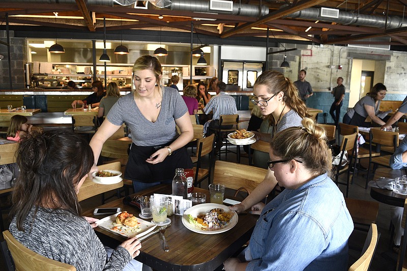 Staff photo by Robin Rudd /
Servers Amanda Helwig, left, and Sarah McKinney bring customers Breck Stewart ,lower left, and Hillary Moore their food.  State of Confusion had its soft opening on August 17, 2018. 