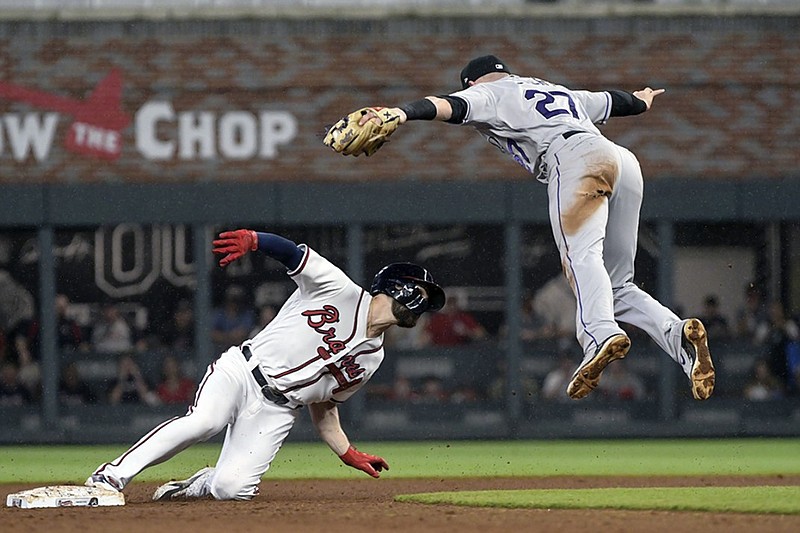 Colorado Rockies shortstop Trevor Story (27) goes high to avoid the Atlanta Braves' Ender Inciarte after catching him stealing second base during the sixth inning of Saturday night's game in Atlanta.
