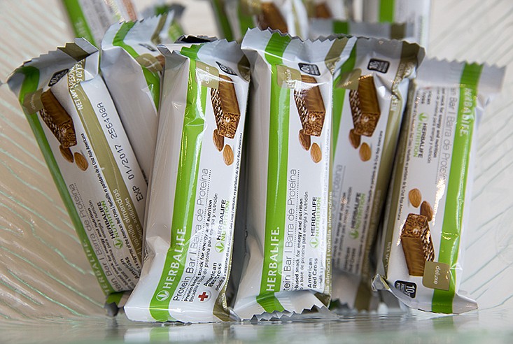 FILE- This May 11, 2016, file photo, shows Herbalife protein bars at Herbalife's corporate office in Los Angeles. Some distributors who claim they were duped by Herbalife's promises they'd get rich selling health and personal care products are suing the company for as much as $1 billion in damages. (AP Photo/Damian Dovarganes, File)