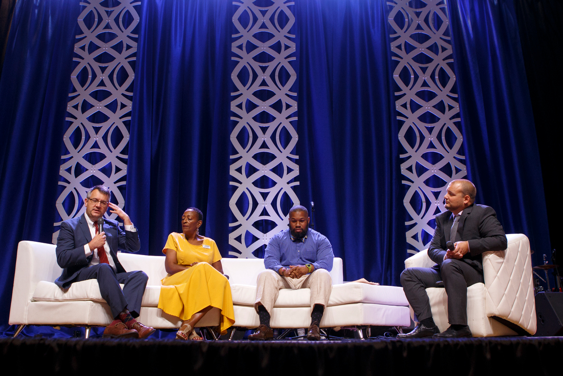 Staff photo by C.B. Schmelter /
As panel moderator Matt Busby, right, and fellow panelists Troy Rogers, second from right, and Karen Nichols look on, North Shore Fellowship Pastor Robby Holt, left, speaks during
