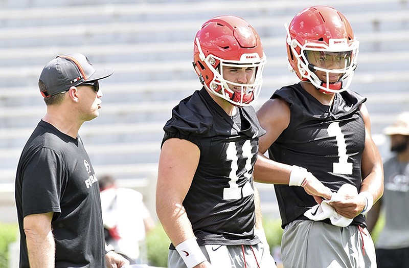 Georgia quarterbacks coach James Coley visits with sophomore with Jake Fromm (11) and freshman Justin Fields during a practice earlier this month at Sanford Stadium.