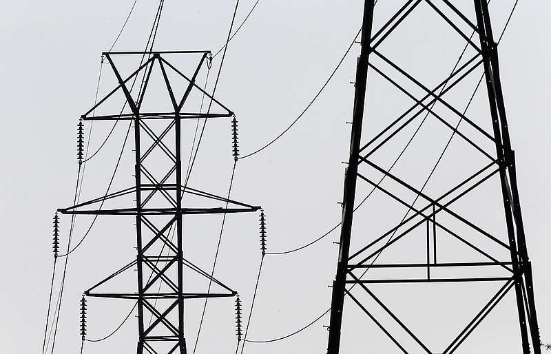 In this photo taken Tuesday, Aug. 14, 2018 power transmission lines deliver electricity along the Interstates 40 and I-85 corridor in Orange County near Hillsborough, N.C. Electric utilities are pouring billions of dollars into a race to prevent terrorists or enemy governments from shutting down the power grid while also making the delivery system ready for a world with much more renewable energy. (AP Photo/Gerry Broome)