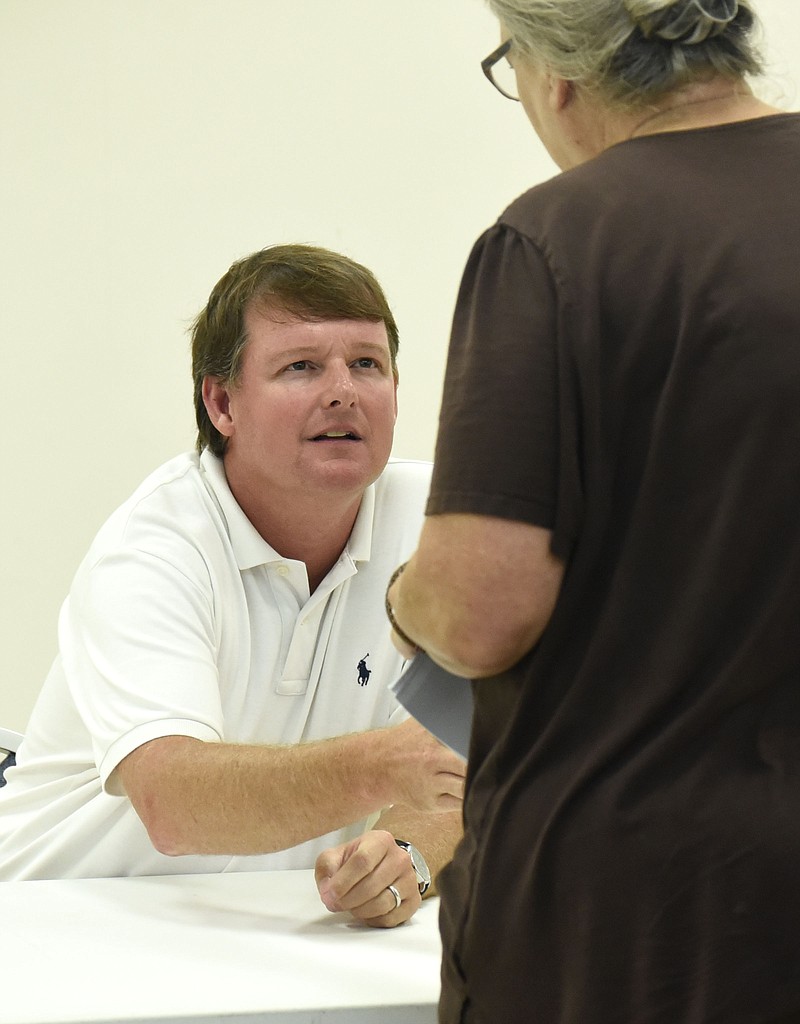 Chattooga County Commissioner Jason Winters listens to a resident's concerns after a meeting. The Georgia Department of Community Affairs awarded the county a $750,000 grant Friday to replace water lines.