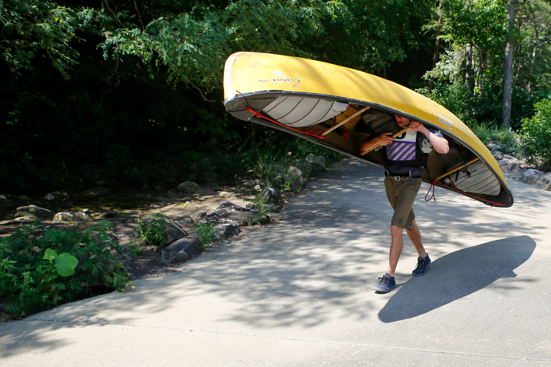 Staff photo by C.B. Schmelter /
Lucien Scott carries a boat to the launch area before competing in the slalom event during the Ocoee River Championships on the 1996 Olympic Section of the Ocoee River on Friday, Aug. 24, 2018 in Copperhill, Tenn.