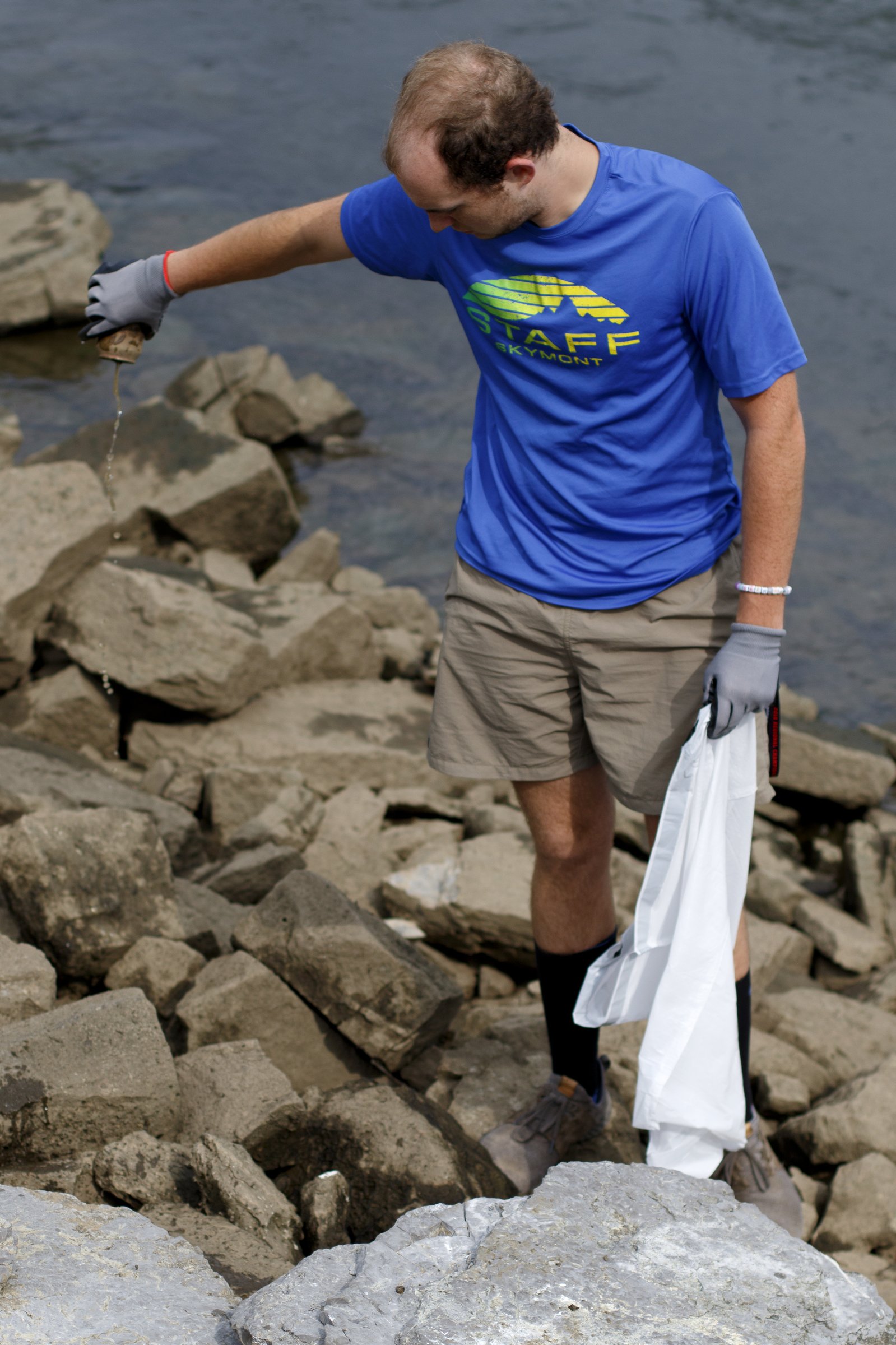 Alex Moore empties a can while picking up trash along the Tennessee Riverwalk at the Chickamauga Dam. Chattanooga-based stewardship group GreenSteps rewards people for helping to clean up the Scenic City's natural areas. To learn more, visit greenstepschatt.com.