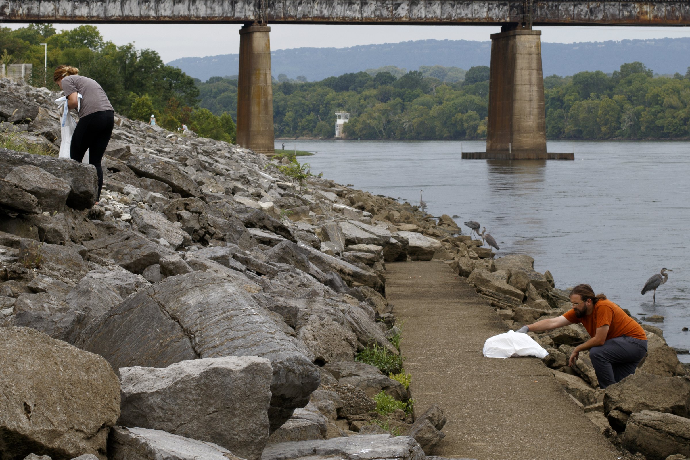 Kristen Woodall, left, and Robert Altonen, the watershed project coordinator for the Southeast Tennessee Resource Conservation and Development Council, help with litter removal along the Tennessee Riverwalk.