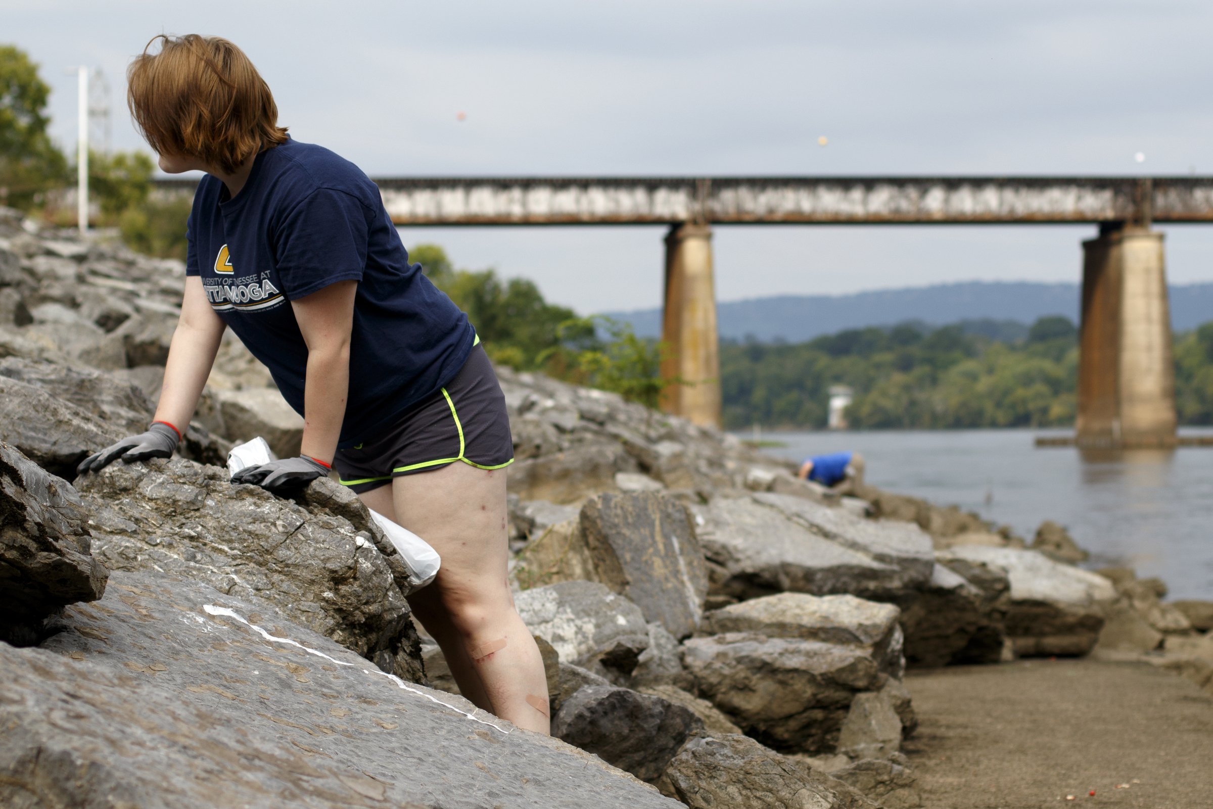 Hailey Mitchell, left, searches for trash while cleaning up along the Tennessee Riverwalk at the Chickamauga Dam.