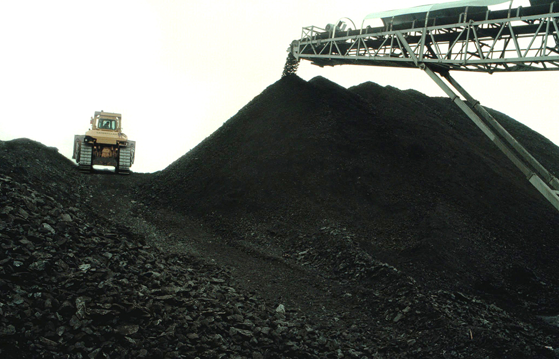 A bulldozer smooths coal as it drops out of the conveyer belt at the KenAmerican Paradise No. 9 mine in Muhlenberg County near Owensboro, Ky.