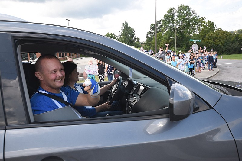 After leaving physical rehabilitation, Major Tommy Bradford gives a thumbs-up to Dade Elementary K-5 students in downtown Trenton.
