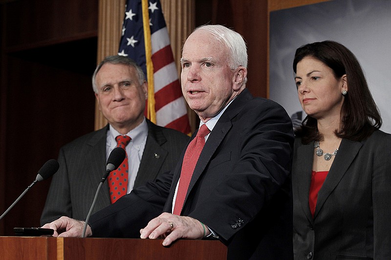 Sen. John McCain, R-Ariz., ranking Republican on the Senate Armed Services Committee, center, flanked by Senate Minority Whip Jon Kyl of Ariz., left, and fellow committee member Sen. Kelly Ayotte, R-N.H., speaks during a news conference on Capitol Hill in Washington, Wednesday, Dec. 14, 2011. (AP Photo/J. Scott Applewhite)