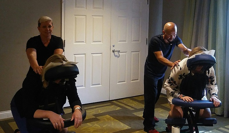 Rebecca Dennison and Chip Phillips are shown offering on-site massages as part of a Hilton Garden Inn Guest Appreciation Day.