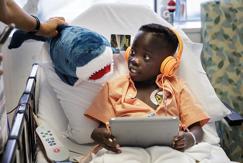 Daniel Prosper Brown looks at his new plush shark, which was delivered by the Chattanooga Zoo, as he receives a blood transfusion to help treat his sickle cell anemia at Children's Hospital at Erlanger on Wednesday, Sept. 5, 2018, in Chattanooga, Tenn. The Chattanooga Zoo collects donated plush animals from visitors to deliver to sick children at the hospital.