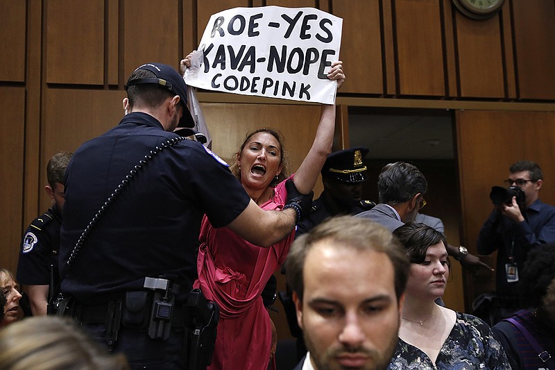 A woman stands and voices her opposition to Supreme Court nominee Brett Kavanaugh during a Senate Judiciary Committee confirmation hearing on his nomination for the Supreme Court in Washington last week. (AP Photo/Jacquelyn Martin)