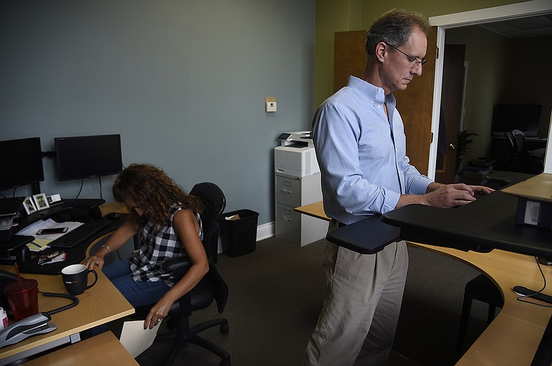 In this Friday, Aug. 17, 2018, photo, Jackie Johnson, left, and John Ahlberg work at Waident Technology Solutions in Glen Ellyn, Ill. Ahlberg, whose technology support and management company has made four acquisitions in recent years, has been able to retain about a third of the staffers who joined his firm, Chicago-based Waident. "With each person, we sit down and talk to them, and ask, 'What are you doing now, and what skills do you have?'" Ahlberg says. "But most of the conversation revolves around, 'What are your hopes and dreams. What do you want to be doing?'" (AP Photo/Annie Rice)