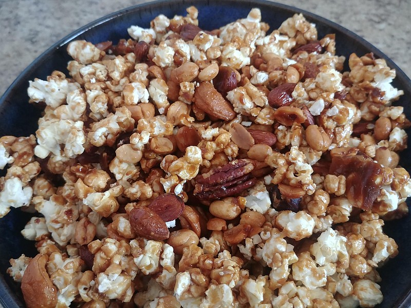 Caramel corn is chock full of nuts and makes a great snack for football parties or a quiet night at home in front of the fire.